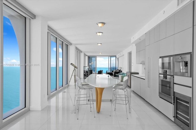 dining room with expansive windows and a water view