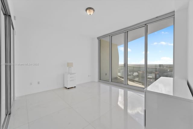 empty room featuring light tile patterned floors and floor to ceiling windows