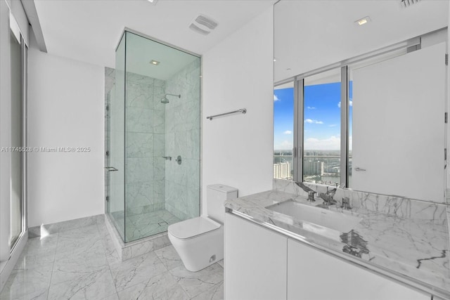 bathroom featuring vanity, a shower with shower door, and toilet