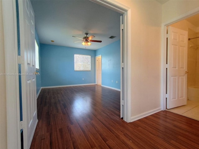 unfurnished room featuring visible vents, baseboards, a ceiling fan, and wood finished floors