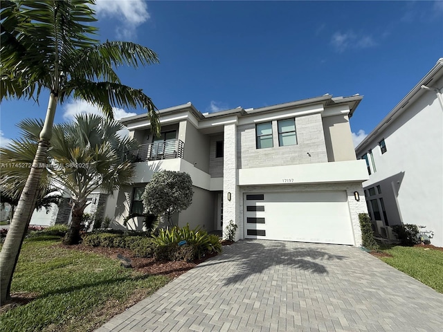 view of front facade with an attached garage, decorative driveway, and stucco siding