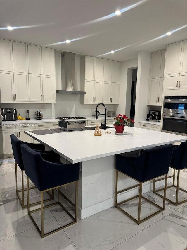 kitchen with stove, a kitchen breakfast bar, light countertops, wall chimney range hood, and double oven