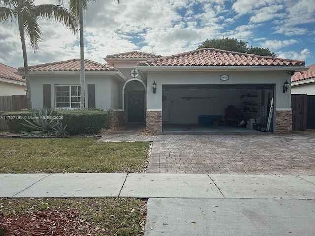 mediterranean / spanish-style home featuring a garage and a front yard