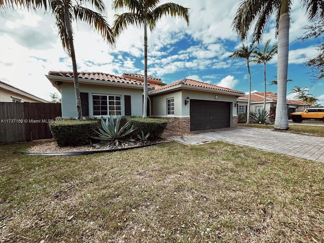 mediterranean / spanish home with a garage and a front lawn