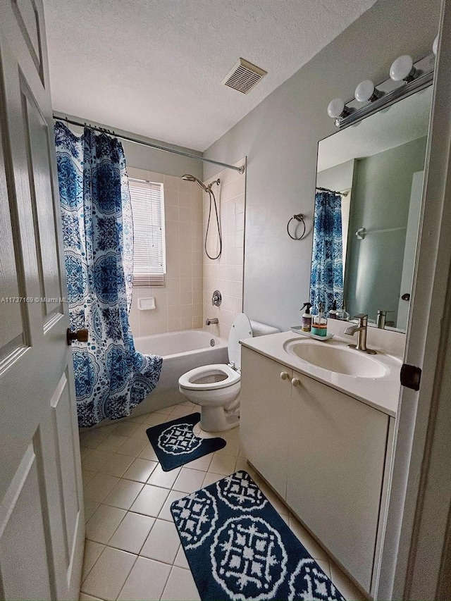 full bathroom featuring shower / bath combination with curtain, tile patterned flooring, vanity, toilet, and a textured ceiling