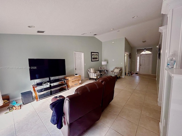 living room featuring light tile patterned flooring, lofted ceiling, and a textured ceiling