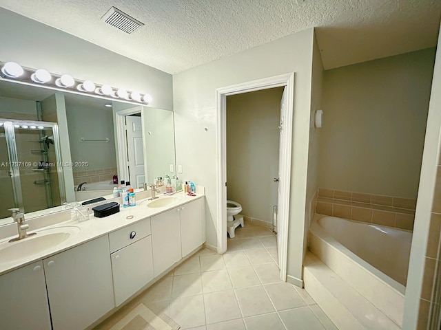 full bathroom featuring shower with separate bathtub, vanity, toilet, tile patterned floors, and a textured ceiling