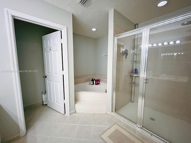 bathroom with tile patterned flooring, independent shower and bath, and a textured ceiling