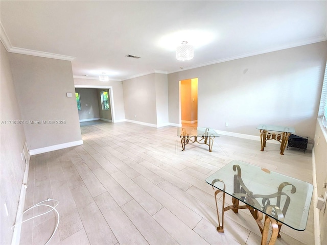 empty room with light wood-style floors, visible vents, ornamental molding, and baseboards