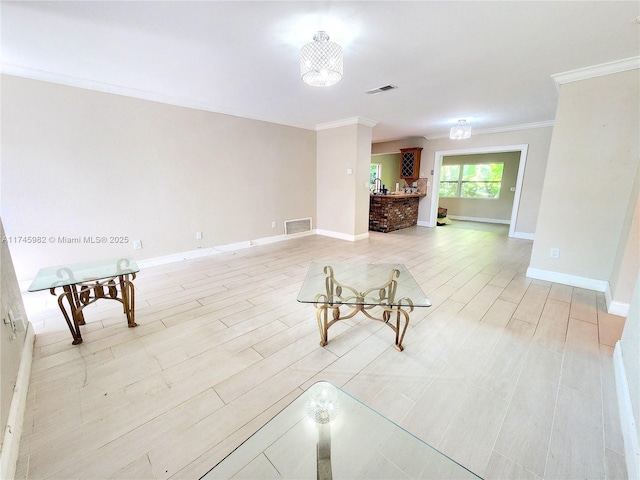 unfurnished living room with ornamental molding, light wood-style flooring, visible vents, and baseboards