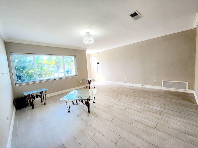 interior space featuring ornamental molding, visible vents, light wood finished floors, and baseboards