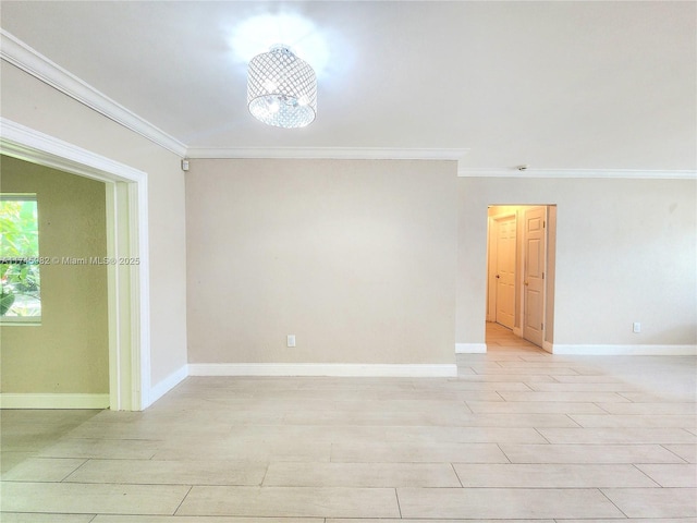 spare room featuring ornamental molding, light wood-style flooring, and baseboards