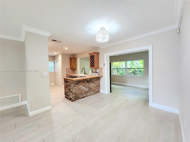 kitchen with light countertops, visible vents, plenty of natural light, and baseboards