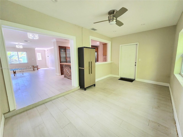 spare room with ceiling fan, visible vents, and baseboards