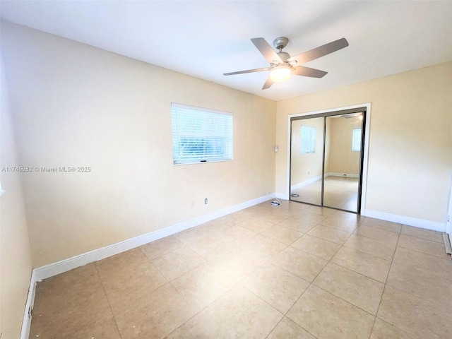 unfurnished bedroom with light tile patterned floors, ceiling fan, baseboards, and a closet