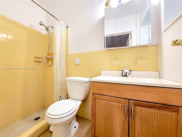 full bath featuring tile patterned flooring, toilet, vanity, tile walls, and a stall shower