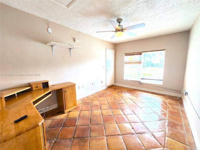 unfurnished office with ceiling fan, a textured ceiling, and baseboards