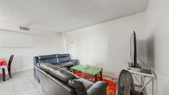 living room with a textured ceiling and light tile patterned floors