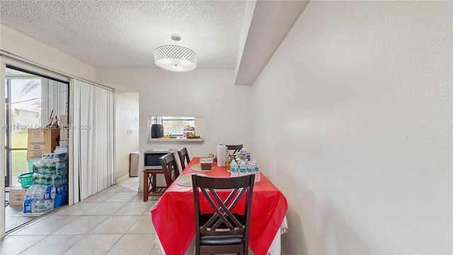 tiled dining area with a textured ceiling