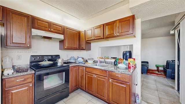 kitchen featuring sink, light tile patterned floors, electric range, and a textured ceiling