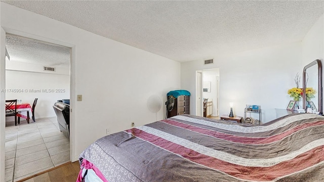 bedroom with a textured ceiling and light wood-type flooring