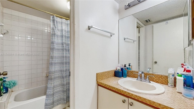 bathroom featuring vanity, shower / tub combo with curtain, and a textured ceiling