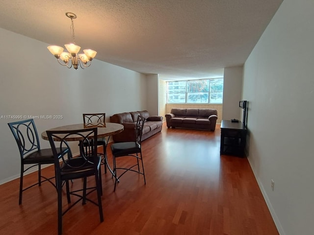 dining area featuring an inviting chandelier, a textured ceiling, dark hardwood / wood-style flooring, and a wall of windows