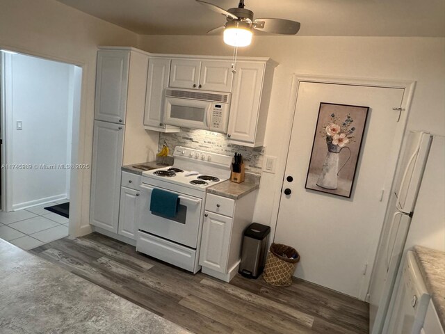 4770 NW 21st St Unit 208, Lauderhill, FL 33313 - kitchen with white appliances, wood finished floors, white cabinets, a ceiling fan, and backsplash