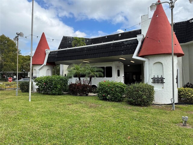 4770 NW 21st St Unit 208, Lauderhill, FL 33313 - rear view of house featuring stucco siding, a yard, mansard roof, and roof with shingles