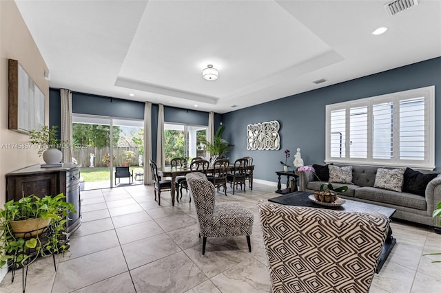 tiled living room with a tray ceiling