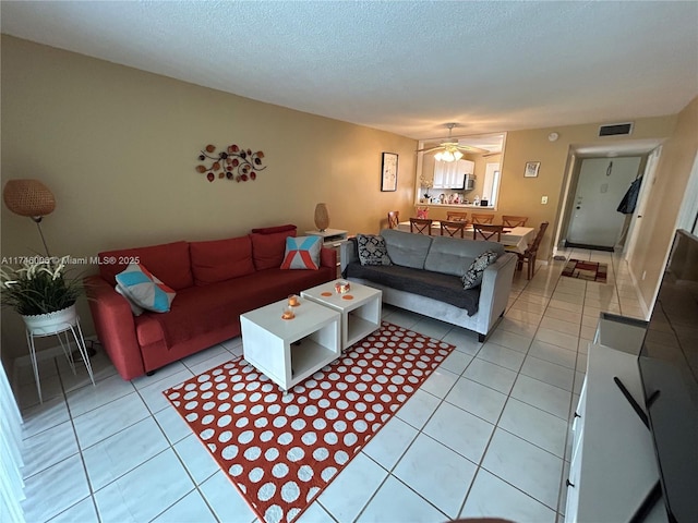 tiled living room featuring ceiling fan and a textured ceiling