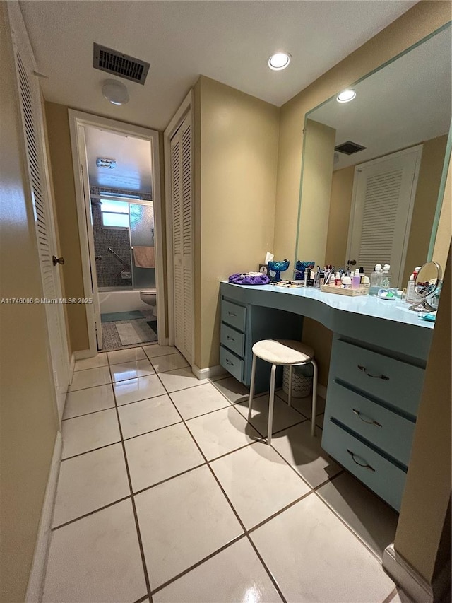 full bathroom with vanity, toilet, tiled shower / bath combo, and tile patterned flooring