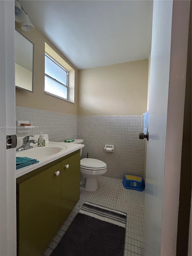 bathroom featuring tile patterned flooring, vanity, tile walls, and toilet