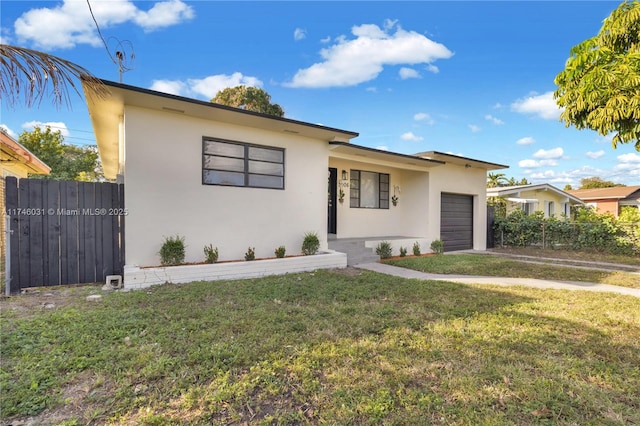 view of front of house featuring a garage and a front lawn