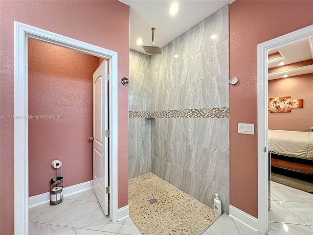 ensuite bathroom featuring marble finish floor, baseboards, and walk in shower