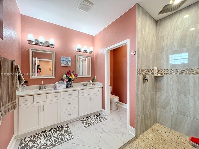 full bathroom with toilet, marble finish floor, a sink, and visible vents