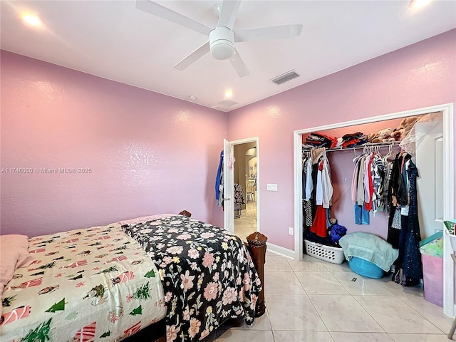 bedroom with light tile patterned floors, visible vents, baseboards, ceiling fan, and a closet