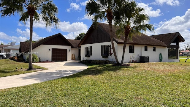 view of front of property featuring a garage, central AC, and a front yard