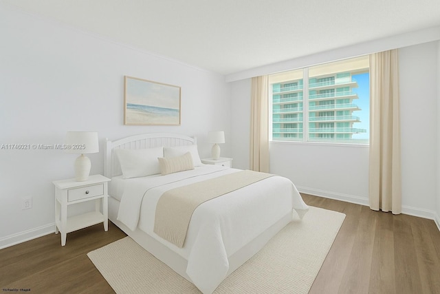 bedroom featuring baseboards and wood finished floors