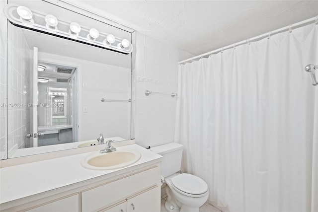 bathroom with vanity, toilet, a textured ceiling, a shower with curtain, and visible vents