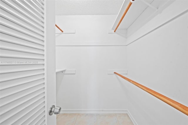 walk in closet with light tile patterned flooring