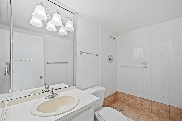 bathroom featuring vanity, toilet, and tiled shower