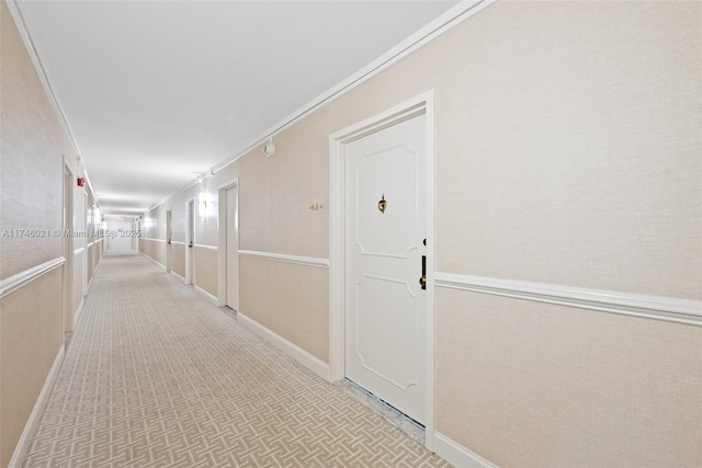 hall with crown molding, baseboards, and tile patterned floors