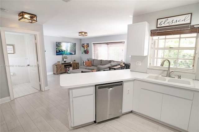 kitchen featuring white cabinets, kitchen peninsula, and dishwasher