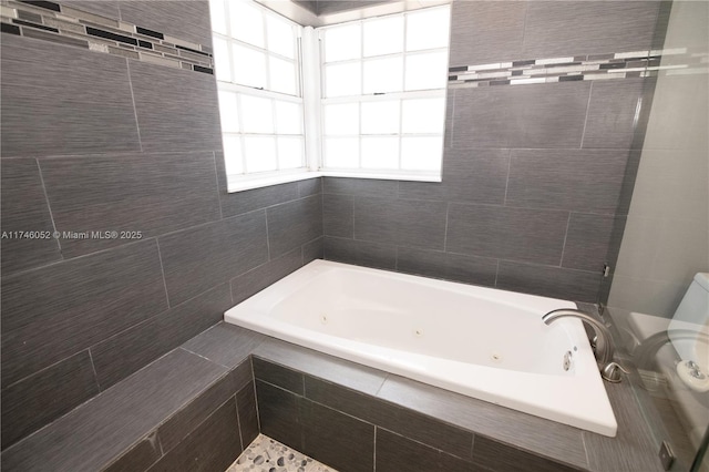 bathroom with a relaxing tiled tub