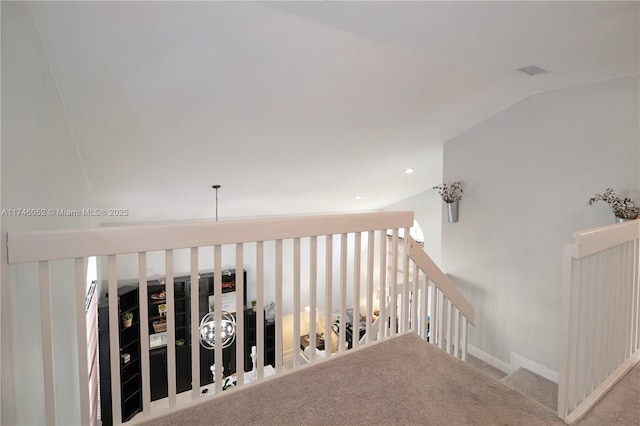 hall with lofted ceiling and light colored carpet