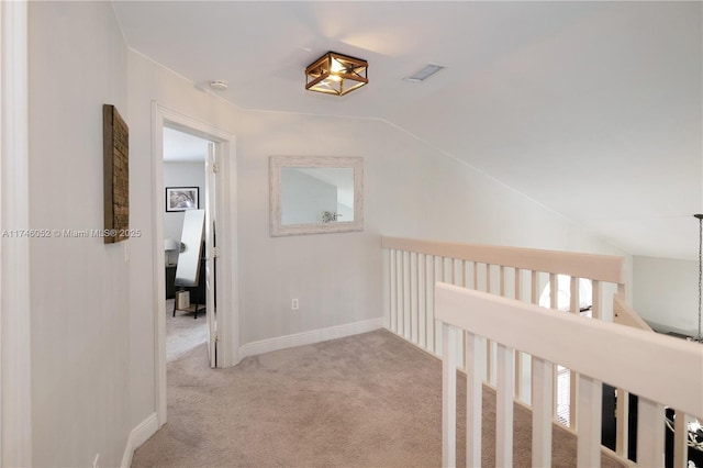 hall with light colored carpet and vaulted ceiling