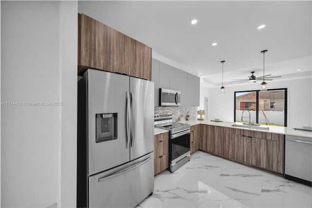 kitchen featuring tasteful backsplash, sink, hanging light fixtures, ceiling fan, and stainless steel appliances