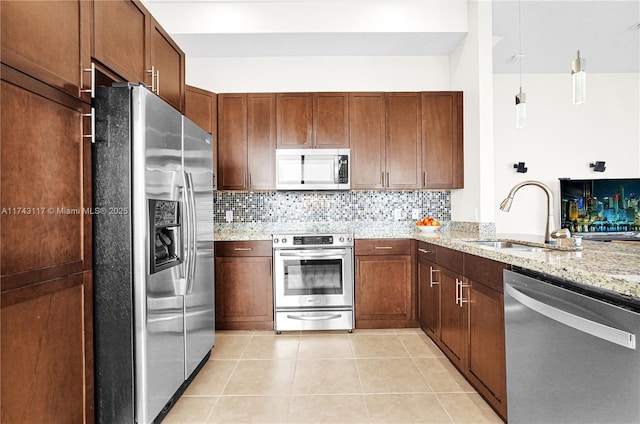 kitchen featuring light tile patterned flooring, sink, appliances with stainless steel finishes, light stone countertops, and decorative backsplash