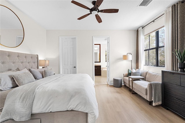 bedroom with light hardwood / wood-style floors, ceiling fan, and ensuite bathroom